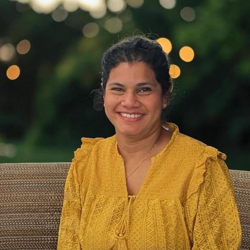 Charmaine Afonso smiling in a mustard blouse