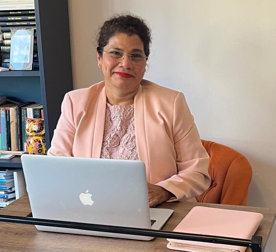 Charmaine Afonso at her desk with her laptop